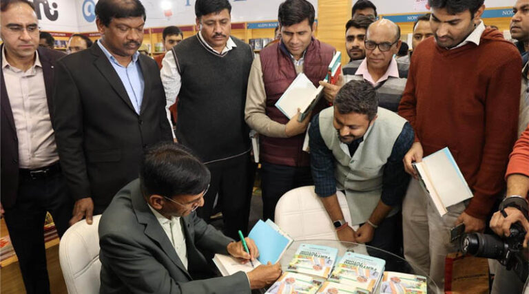 Union Fertilizers Minister Dr Mansukh Mandaviya signs copies of his book "Fertilising The Future” at World Book Fair